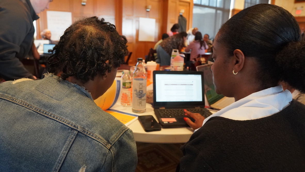Two staff members collaborating at a laptop